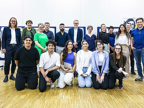 Gruppenfoto vor Ausstellungsplakaten