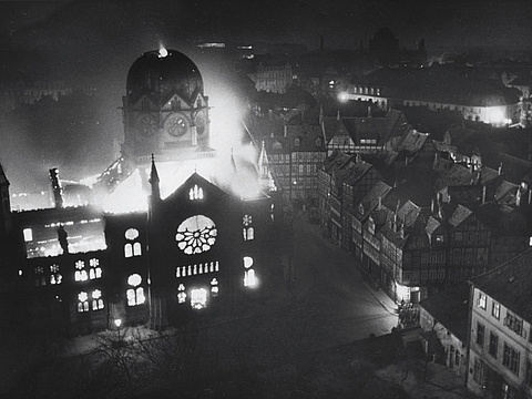 Eine Synagoge, die in Flammen steht von oben fotografiert.