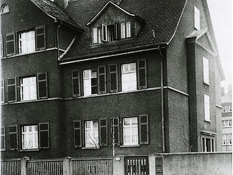 Blick von der Straße auf die Vorderseite eines Hauses.