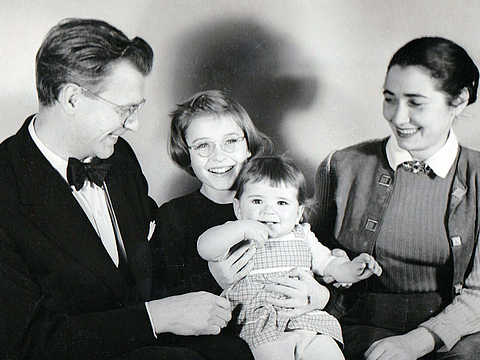 Eine vierköpfige Familie, alle lachen fröhlich.