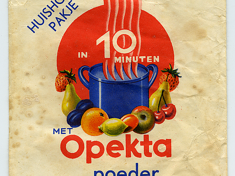 Ein Foto von einer Papiertüte, die am unteren Rand geöffnet ist. Auf der Tüte ist ein blauer Kochtopf und um ihn herum liegendes Obst abgebildet. Auf der Papiertüte stehen Wörter auf Niederländisch geschrieben.